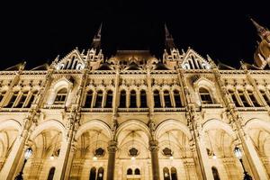 The Hungarian Parliament in Budapest on the Danube in the night lights of the street lamps photo