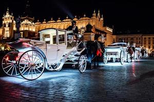 Krakow, Poland 2017- The old square of the night in Krakow with horse-drawn carriages photo