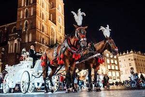 Krakow, Poland 2017- The old square of the night in Krakow with horse-drawn carriages photo