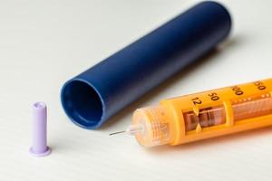 Primer plano de un inyector de insulina tipo pluma desechable