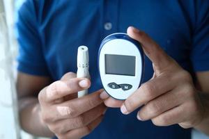 Man holding tools to measure blood sugar photo