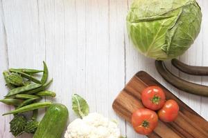 Selección de alimentos saludables con verduras frescas en una tabla de cortar foto