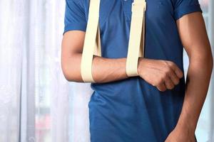 Hombre de camisa azul con cabestrillo foto