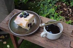 café con un trozo de tarta en la mesa de madera foto