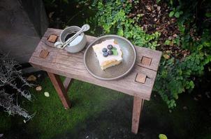 café con un trozo de tarta en la mesa de madera foto