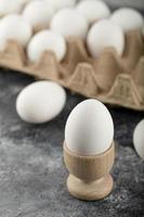 A wooden eggcup with a boiled chicken egg photo