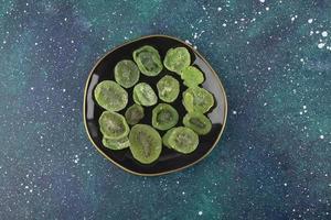 A black plate full of dried kiwi fruit photo