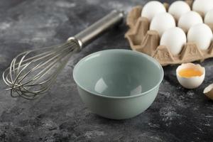 Huevos blancos en un recipiente de cartón y un bigote sobre un fondo de mármol foto