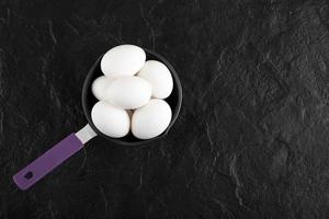huevos blancos crudos en una sartén pequeña foto