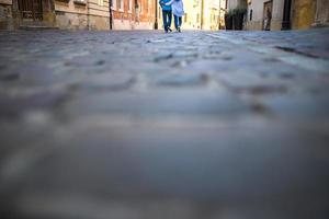 A guy and a girl on an old cobblestone street in Europe