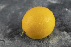un limón maduro amarillo sobre un fondo de mármol