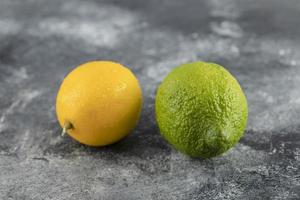 Yellow and green lemons on a marble background photo