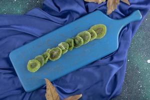 Dried kiwi fruit on a blue wooden board photo