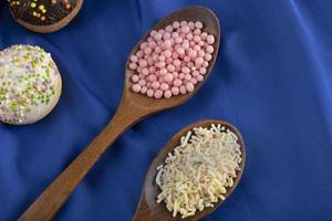 Wooden spoons full of colorful sprinkles photo