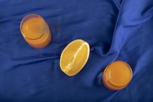 Two glass pitchers with delicious juice and sliced orange fruit photo