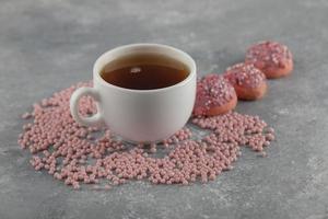 rosquillas dulces rosas con una taza de té foto
