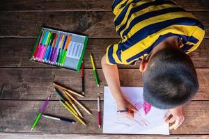 niño dibujando con lápices de colores foto