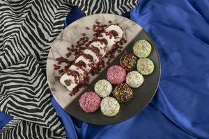 Colorido conjunto de dulces rosquillas pequeñas en un plato foto