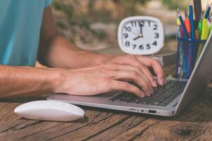 A man typing on a laptop computer photo
