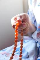 Woman holding prayer beads photo