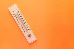 Close up of temperature measurement tools orange background photo