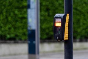 Crosswalk button for pedestrian with light warning on a defocused background photo