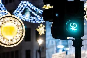 Pedestrian semaphore with green light and defocused Christmas street decorations photo