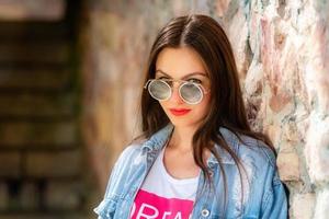 Outdoor portrait of beautiful, young woman in sunglasses