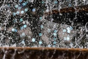 A close-up of a splash of water with a Christmas garland in a defocused background photo