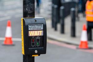 Crosswalk button for pedestrian with light warning on a defocused background photo