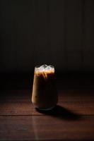 Glass of iced coffee with milk on the table photo