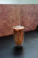 Glass of iced coffee with milk on the table photo