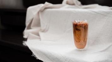 Iced coffee with milk on white fabric photo