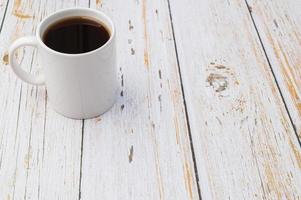 una taza de café en un escritorio de madera foto