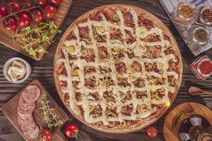 Pizza with mozzarella, calabrese sausage, eggs, catupiry, olive and oregano photo