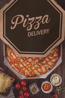 pizza con seis tipos de quesos, mozzarella, provolone, parmesano, catupiry, cheddar y gorgonzola en una caja de entrega foto