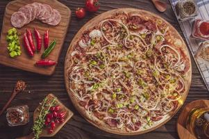 pizza con mozzarella, chorizo calabrese, pimiento verde, cebolla y pimiento calabrese foto