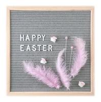 Letterboard with text Happy Easter with pink feathers and toy rabbits photo
