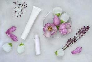 Medicina herbaria con flores de magnolia y lavanda, placas de Petri, tubos de cosméticos y fondo natural para el cuidado de la piel. foto