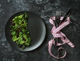 Ensalada dietética de hojas de lechuga, espinacas y guisantes sobre un fondo oscuro
