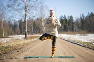 A young athletic woman performs yoga and meditation exercises outdoors photo