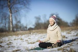 A young athletic woman performs yoga and meditation exercises outdoors