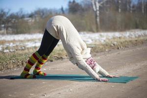 A young athletic woman performs yoga and meditation exercises outdoors photo