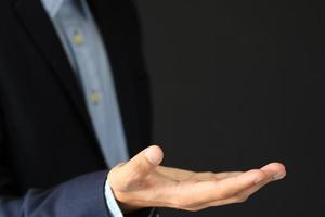 Businessman making a hand gesture hand on a gray background photo