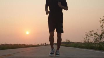 silhueta asiática corredor corre na rua no campo com ar puro e limpo, homem correndo ou treino para uma boa saúde no pôr do sol, conceito de cuidados saudáveis