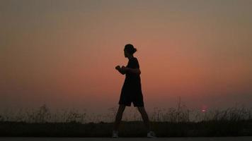 Silhouette der asiatischen Läuferübungen auf der Straße in der Landschaft mit frischer und klarer Luft, laufendes Manntraining, Gesundheitskonzept