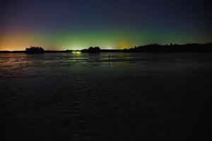 Aurora boreal sobre un lago congelado en Littoinen, Finlandia foto