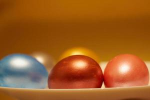 Pearly-colored Easter eggs in an egg carton on a golden background photo