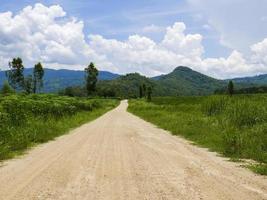 Dirt road in tropical mountain valley photo
