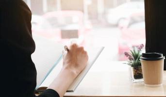 Woman writing in a notebook at a desk photo